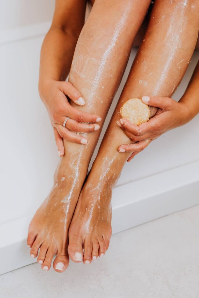 Frau cremt ihre Beine ein – Beauty-Behandlung für glatte und gepflegte Haut.