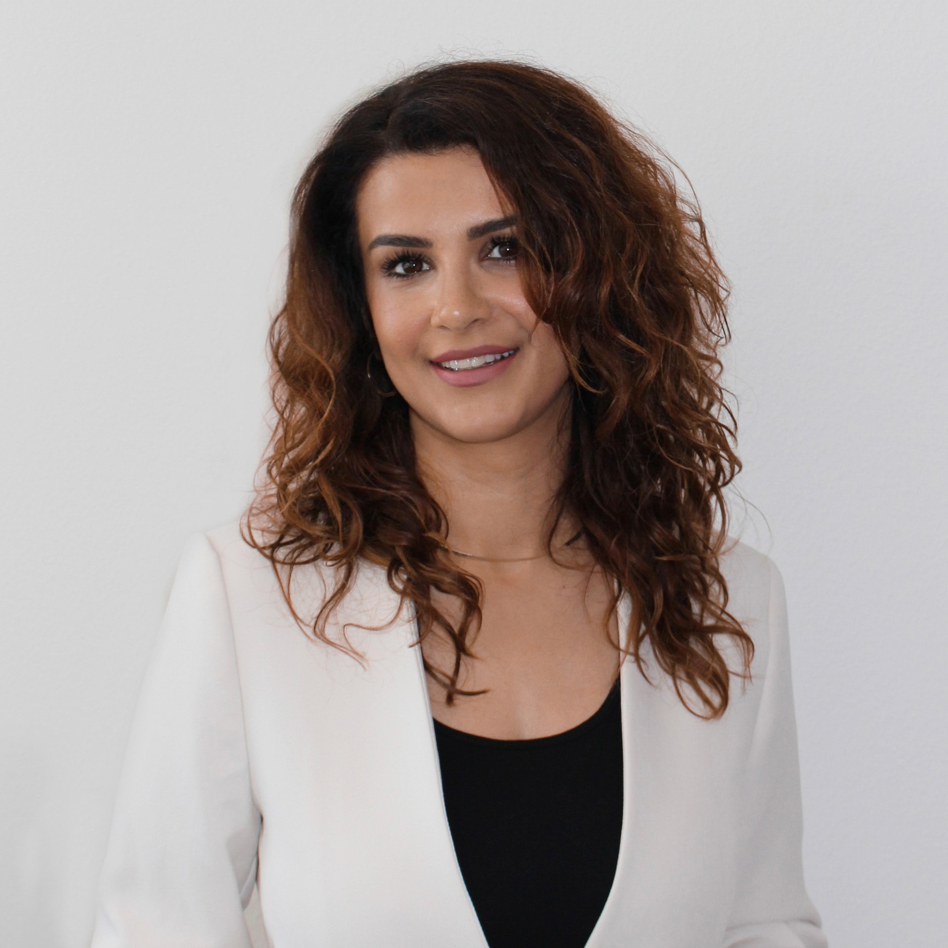 Man sieht die Inhaberin von Hairfree & Aesthetics auf diesem Bild. Eine tolle Frau mit lockiger Frisur und professionellem Auftreten.