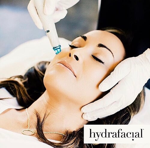 Frau erhält eine Hydrafacial-Behandlung mit einem Gerät – intensive Pflege und Reinigung.
